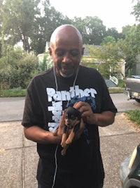 a man holding a small dog in his arms