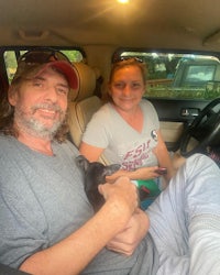 a man and woman sitting in the back seat of a car